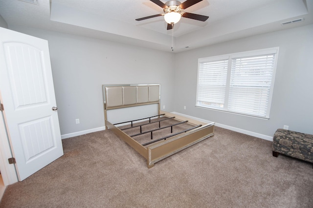 unfurnished bedroom featuring a raised ceiling and carpet floors