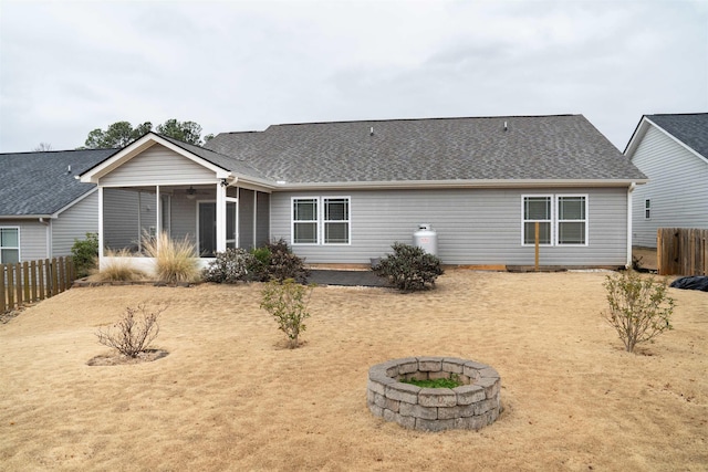 back of house with a sunroom and a fire pit