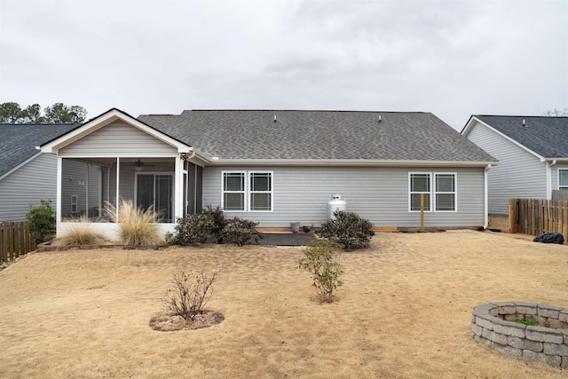 back of house with a sunroom, ceiling fan, and a fire pit