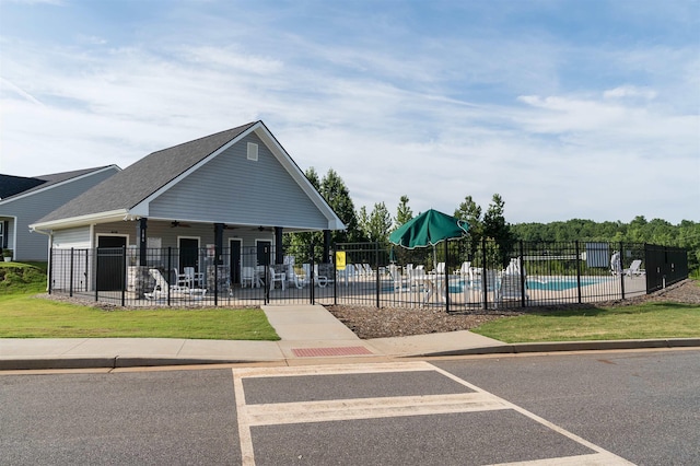 surrounding community with a pool, a patio, and a lawn