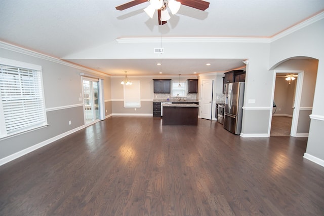 unfurnished living room with lofted ceiling, sink, crown molding, dark hardwood / wood-style floors, and ceiling fan with notable chandelier