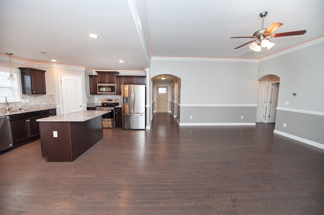 kitchen featuring a kitchen island, tasteful backsplash, sink, dark brown cabinetry, and stainless steel appliances