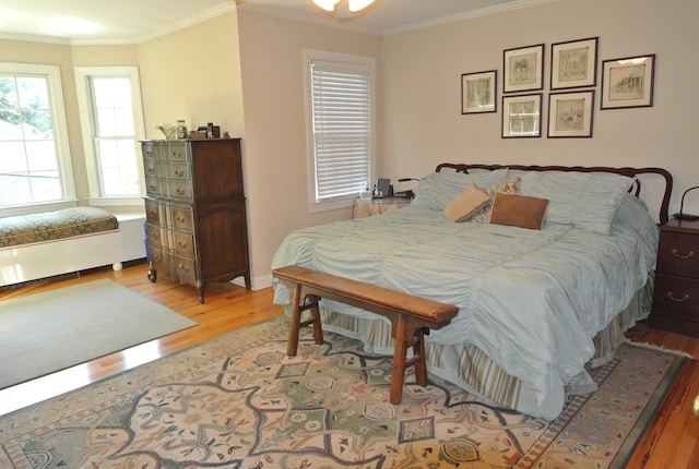 bedroom featuring crown molding and light hardwood / wood-style floors