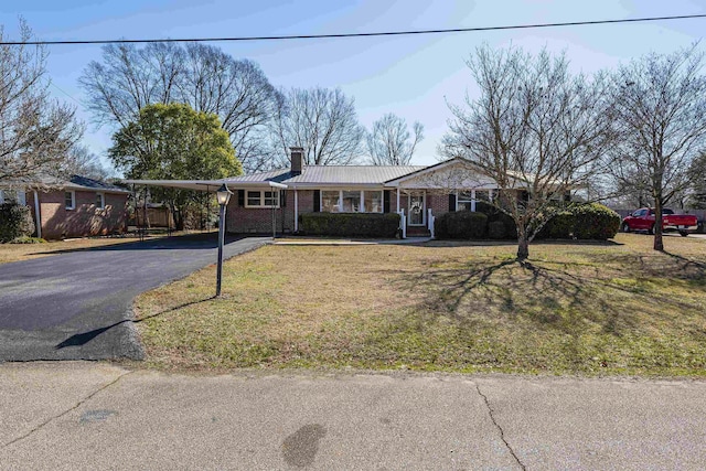 ranch-style house featuring a carport and a front lawn