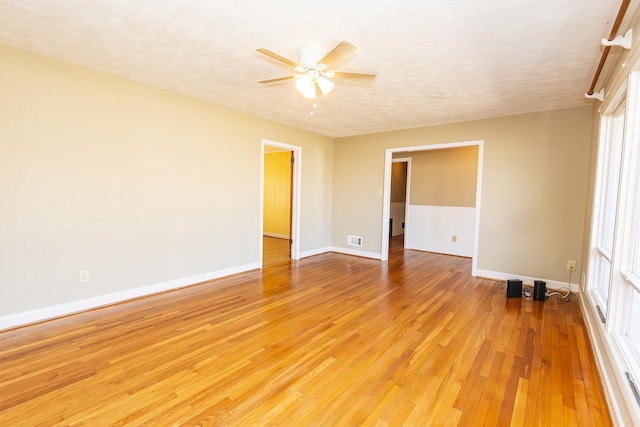 unfurnished room featuring ceiling fan, light hardwood / wood-style floors, and a textured ceiling