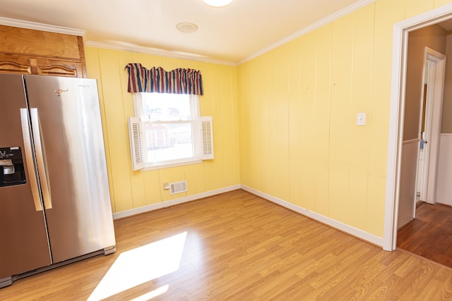 interior space featuring stainless steel refrigerator with ice dispenser, crown molding, and light wood-type flooring