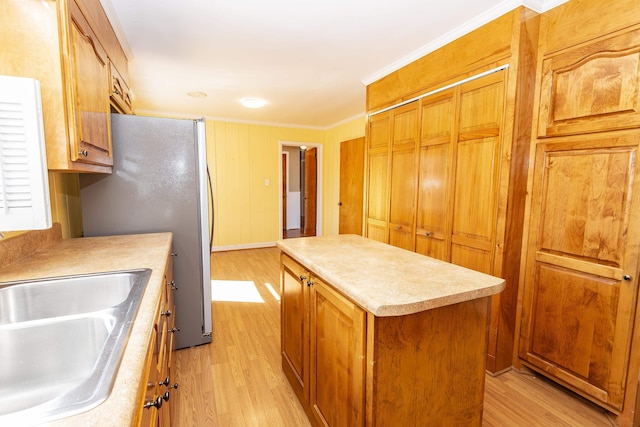 kitchen featuring crown molding, light hardwood / wood-style floors, sink, and a kitchen island