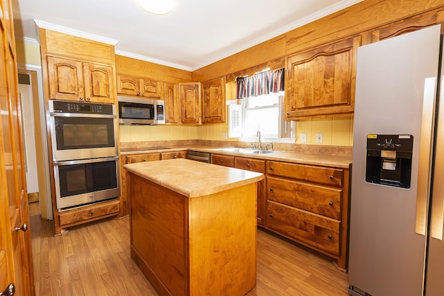 kitchen with sink, light hardwood / wood-style flooring, stainless steel appliances, and a center island