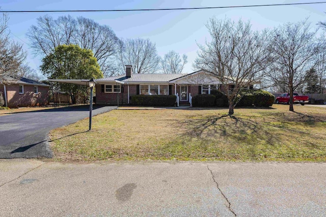 ranch-style home featuring a front yard and a carport