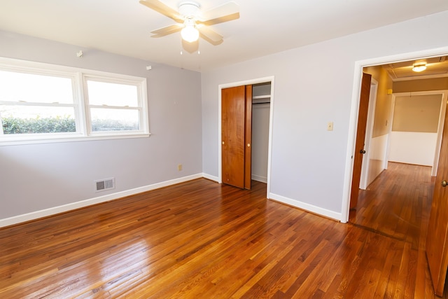 unfurnished bedroom featuring ceiling fan, dark hardwood / wood-style flooring, and a closet