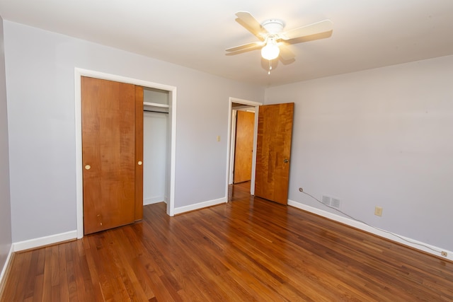 unfurnished bedroom featuring a closet, dark hardwood / wood-style floors, and ceiling fan