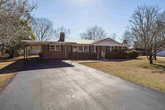 single story home with a carport, covered porch, and a front lawn