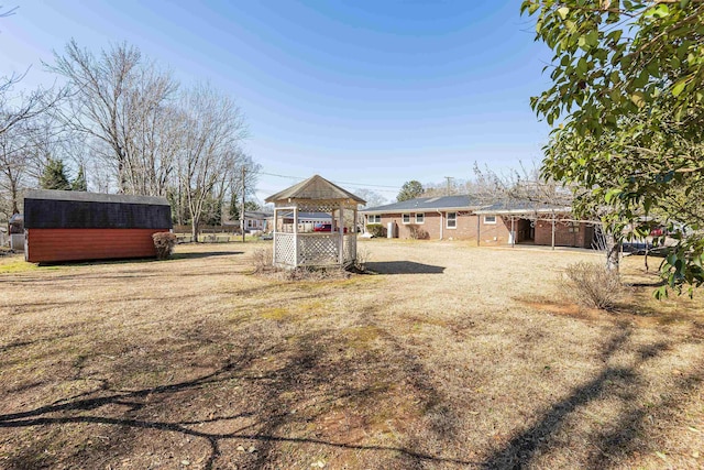 view of yard featuring a gazebo and a shed