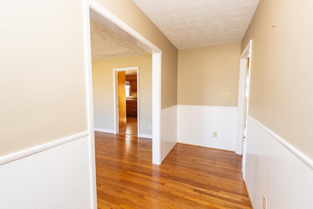 hallway with wood-type flooring and a textured ceiling