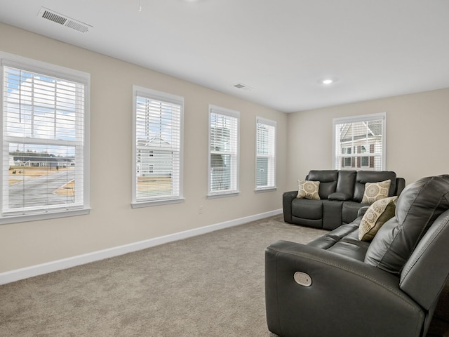 living room featuring a wealth of natural light and light colored carpet