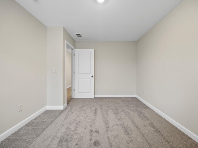 unfurnished room featuring light colored carpet