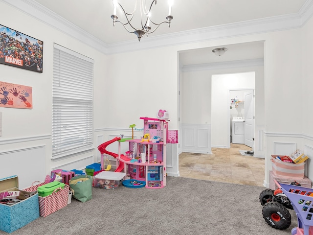 playroom featuring crown molding, washer / clothes dryer, light carpet, and a notable chandelier