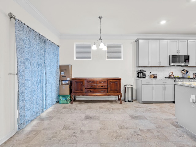 kitchen featuring backsplash, hanging light fixtures, crown molding, light stone countertops, and an inviting chandelier