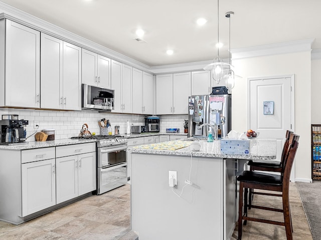 kitchen featuring light stone counters, tasteful backsplash, pendant lighting, stainless steel appliances, and a kitchen island with sink