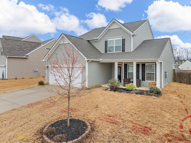 view of front of house with a garage, covered porch, and a front yard