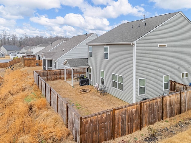 back of property with a patio and an outdoor fire pit