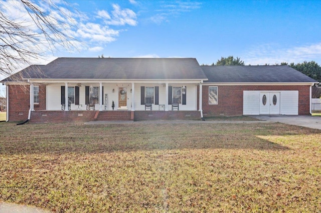 ranch-style house featuring a garage, covered porch, and a front yard