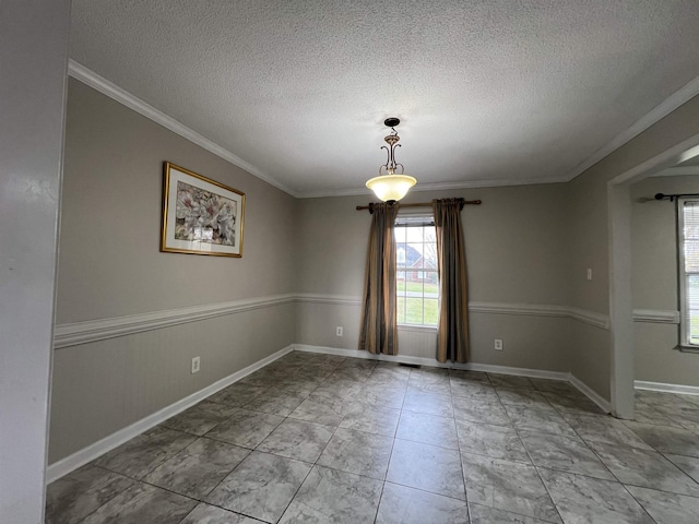 spare room featuring crown molding and a textured ceiling