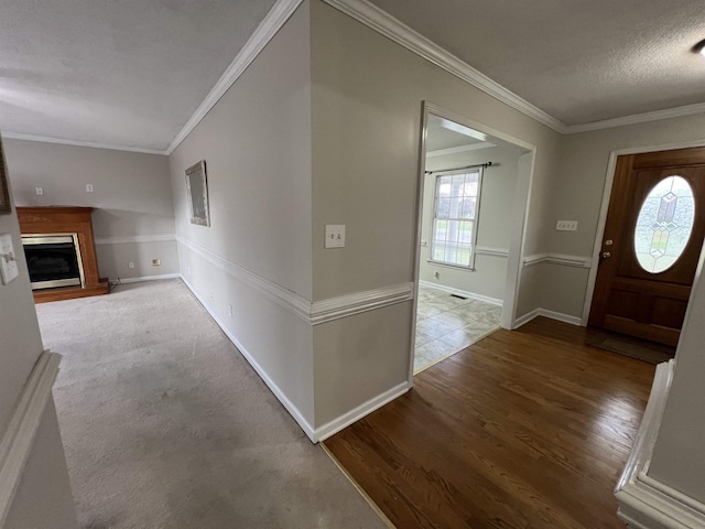 entrance foyer featuring ornamental molding, wood-type flooring, and a textured ceiling