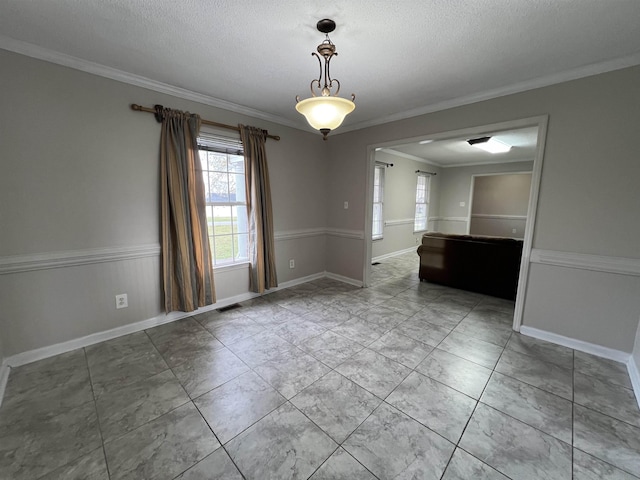 spare room with crown molding and a textured ceiling