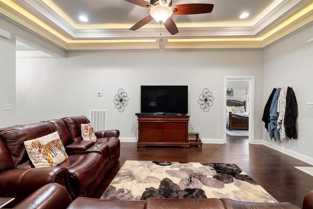 living room featuring crown molding, ceiling fan, dark hardwood / wood-style flooring, and a tray ceiling