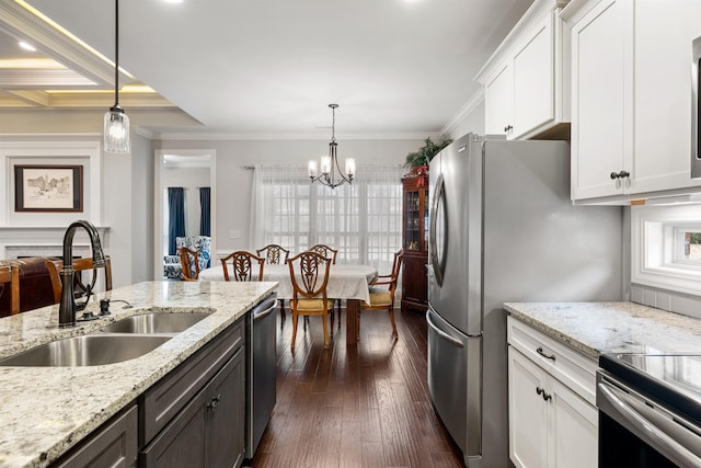 kitchen featuring light stone counters, decorative light fixtures, sink, and white cabinets