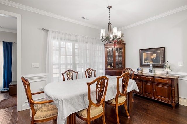 dining room featuring ornamental molding, dark wood-type flooring, and a chandelier