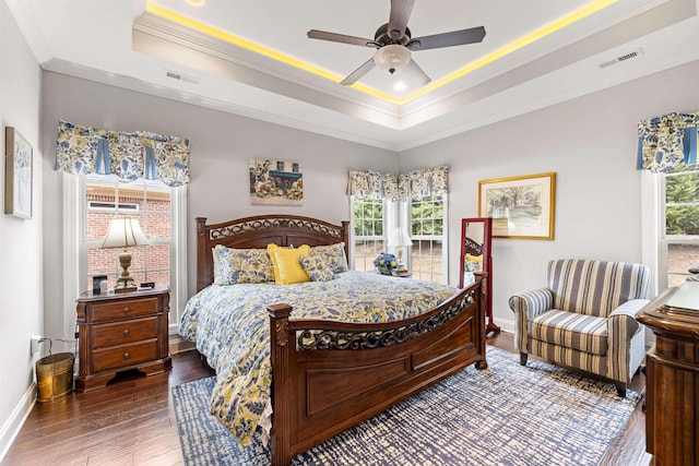 bedroom featuring crown molding, ceiling fan, a tray ceiling, and hardwood / wood-style flooring