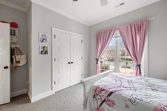 bedroom with crown molding, ceiling fan, carpet flooring, and a closet