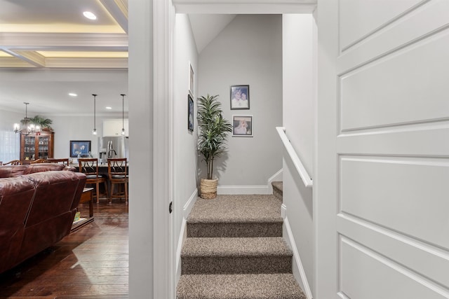 stairway featuring a notable chandelier, crown molding, and hardwood / wood-style floors