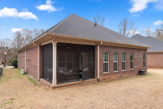 rear view of property featuring cooling unit, a yard, and a sunroom