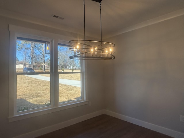 unfurnished dining area with hardwood / wood-style flooring and an inviting chandelier