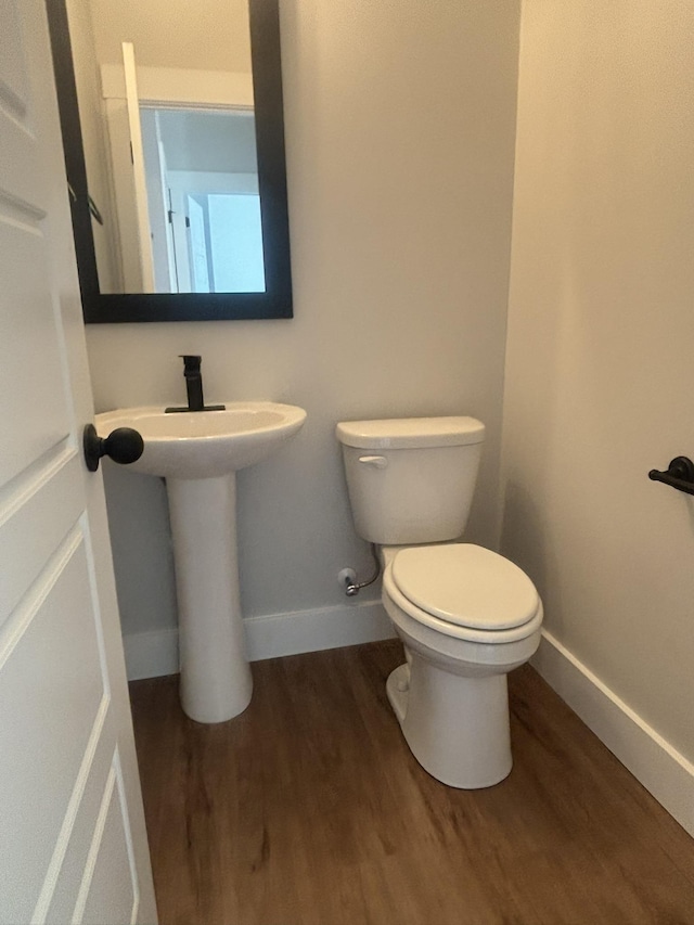 bathroom featuring wood-type flooring and toilet