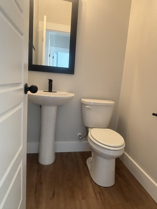 bathroom featuring hardwood / wood-style flooring and toilet