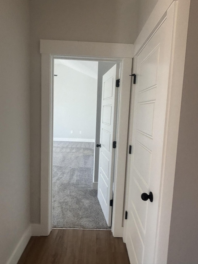 corridor with dark hardwood / wood-style flooring