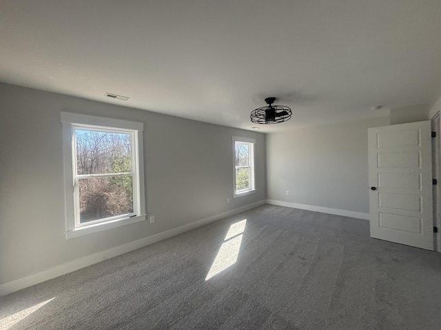 unfurnished room with dark colored carpet