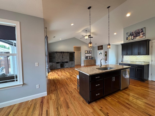 kitchen with sink, a center island with sink, light hardwood / wood-style flooring, stainless steel dishwasher, and light stone countertops