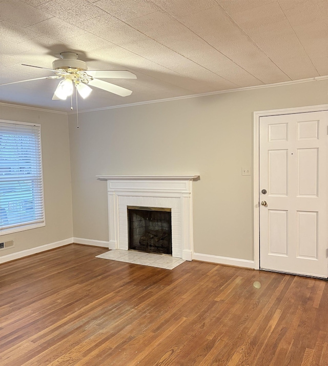 unfurnished living room with crown molding, ceiling fan, wood-type flooring, a textured ceiling, and a brick fireplace