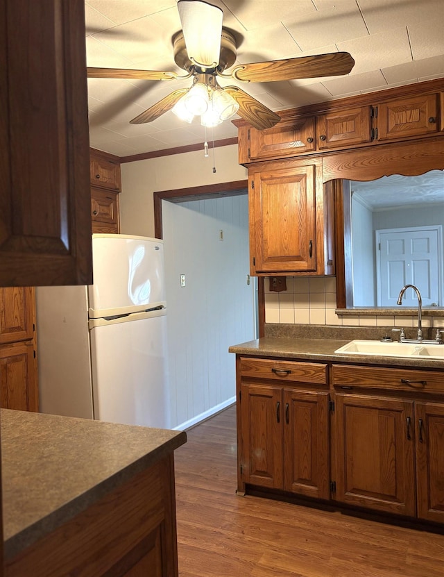 kitchen with dark hardwood / wood-style floors, sink, backsplash, white fridge, and ceiling fan