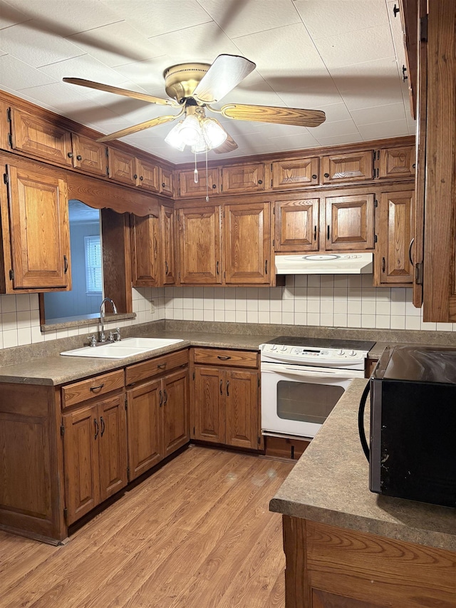 kitchen featuring sink, light hardwood / wood-style flooring, ceiling fan, white range with electric stovetop, and decorative backsplash