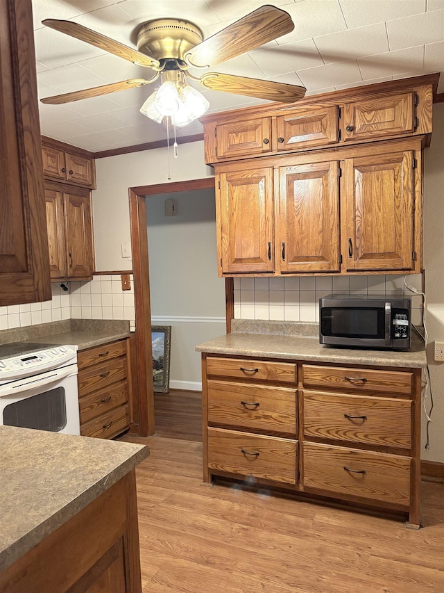 kitchen with decorative backsplash, light hardwood / wood-style flooring, ceiling fan, and white range with electric cooktop