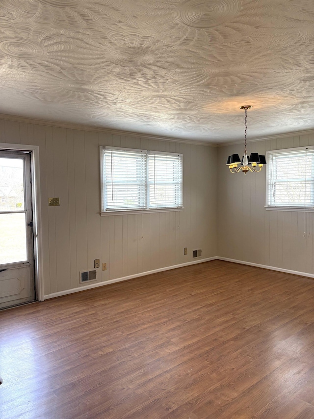 unfurnished room with hardwood / wood-style floors and a chandelier