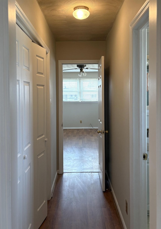 corridor with dark hardwood / wood-style flooring