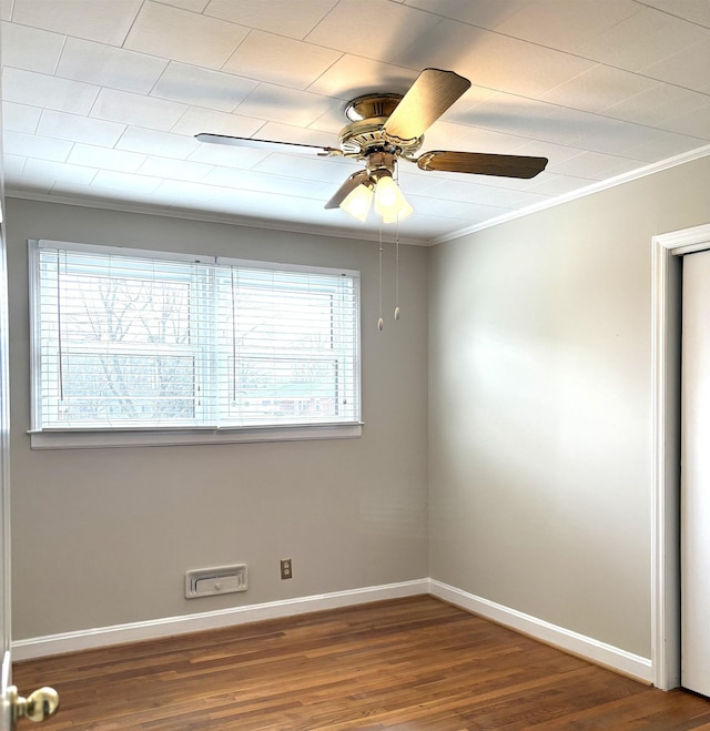 empty room featuring crown molding, a healthy amount of sunlight, hardwood / wood-style floors, and ceiling fan