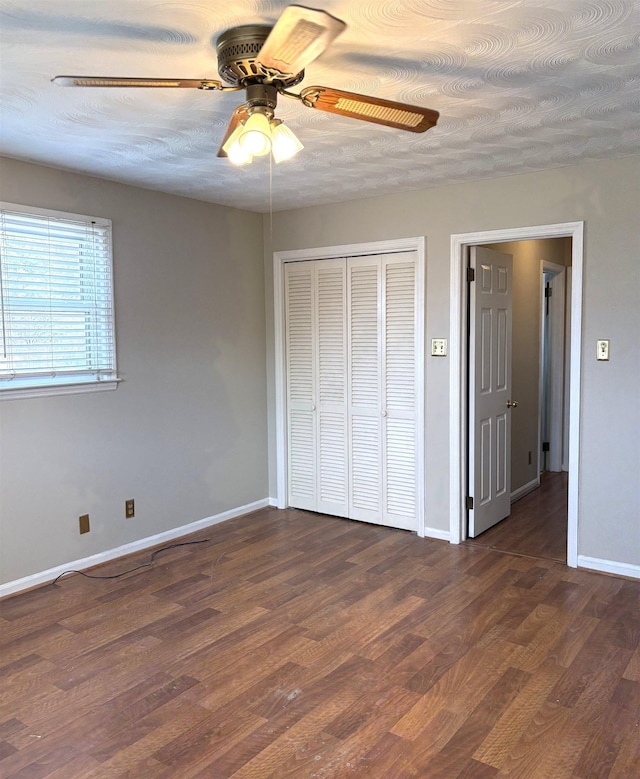 unfurnished bedroom featuring ceiling fan, dark hardwood / wood-style flooring, a closet, and a textured ceiling